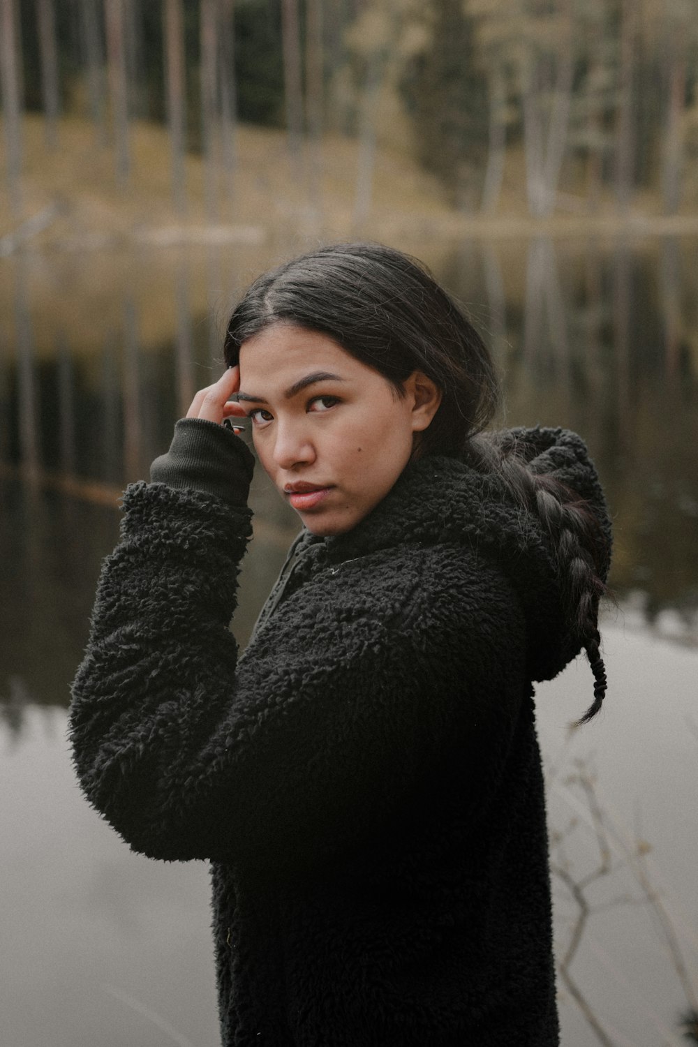 woman in black coat standing on snow covered ground during daytime