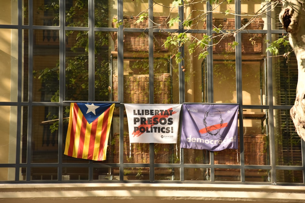 flags on poles near trees during daytime