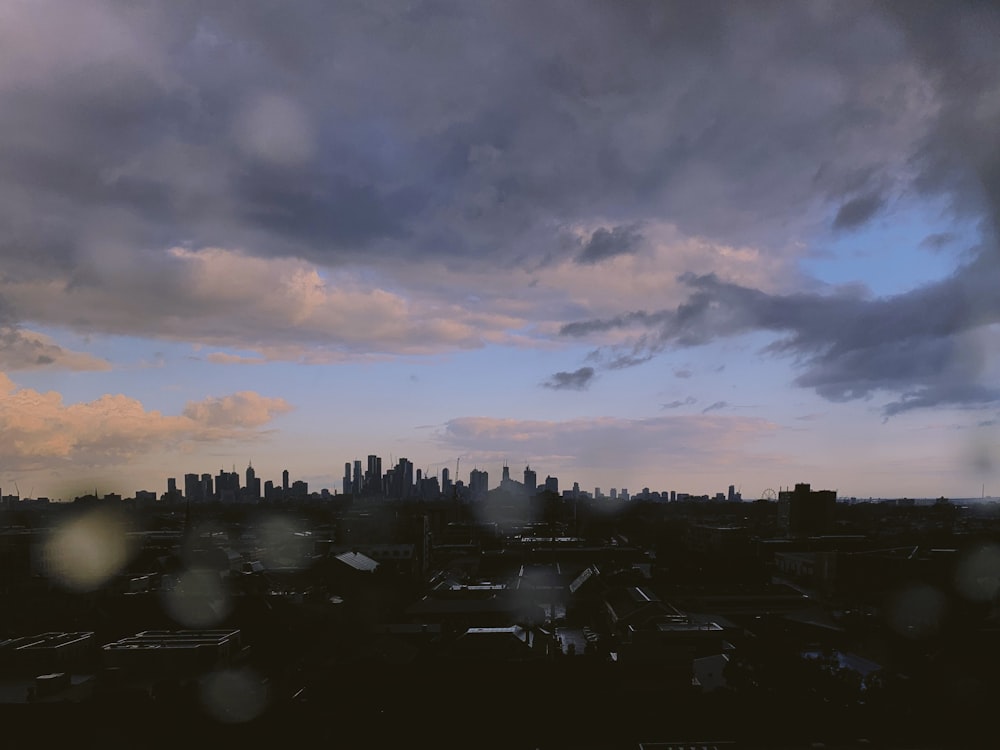 silhouette of city under cloudy sky during daytime