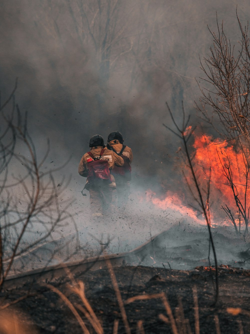 3 men in black jacket and black pants playing with fire