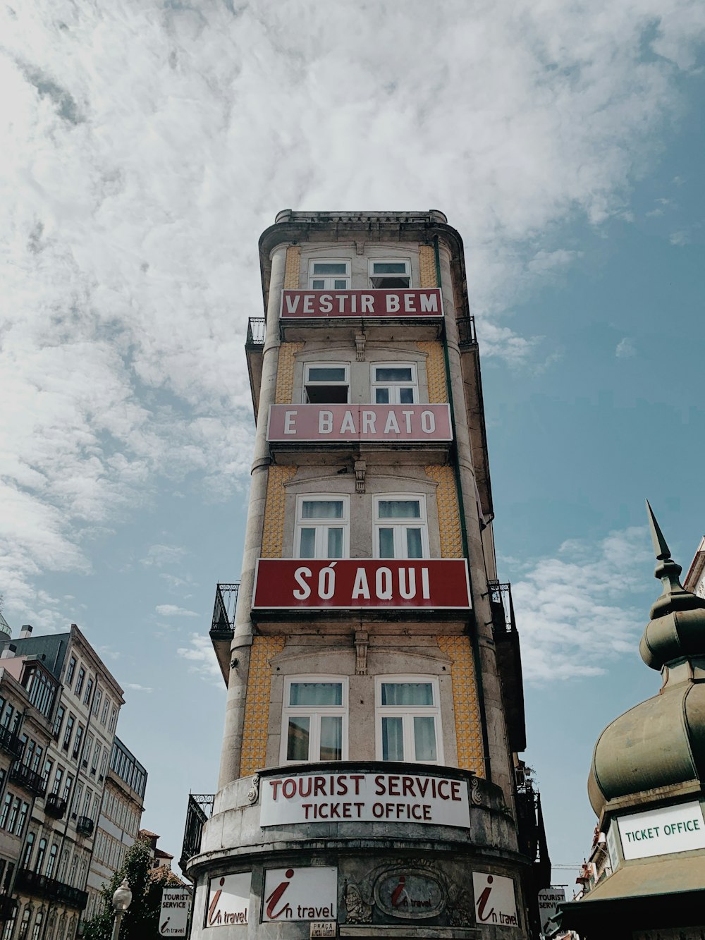 red and white concrete building under white clouds during daytime