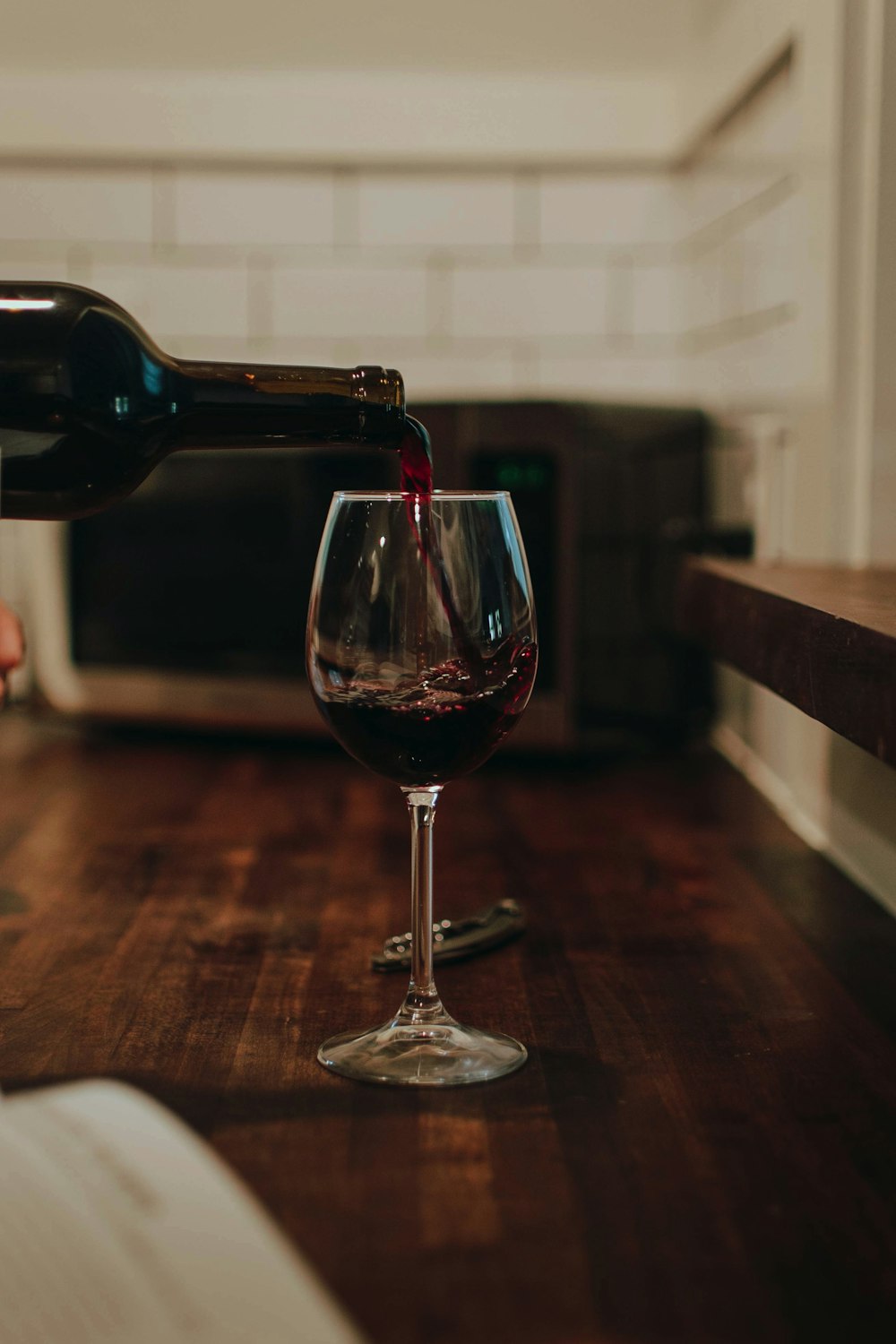 茶色の木製のテーブルに透明なワイングラス