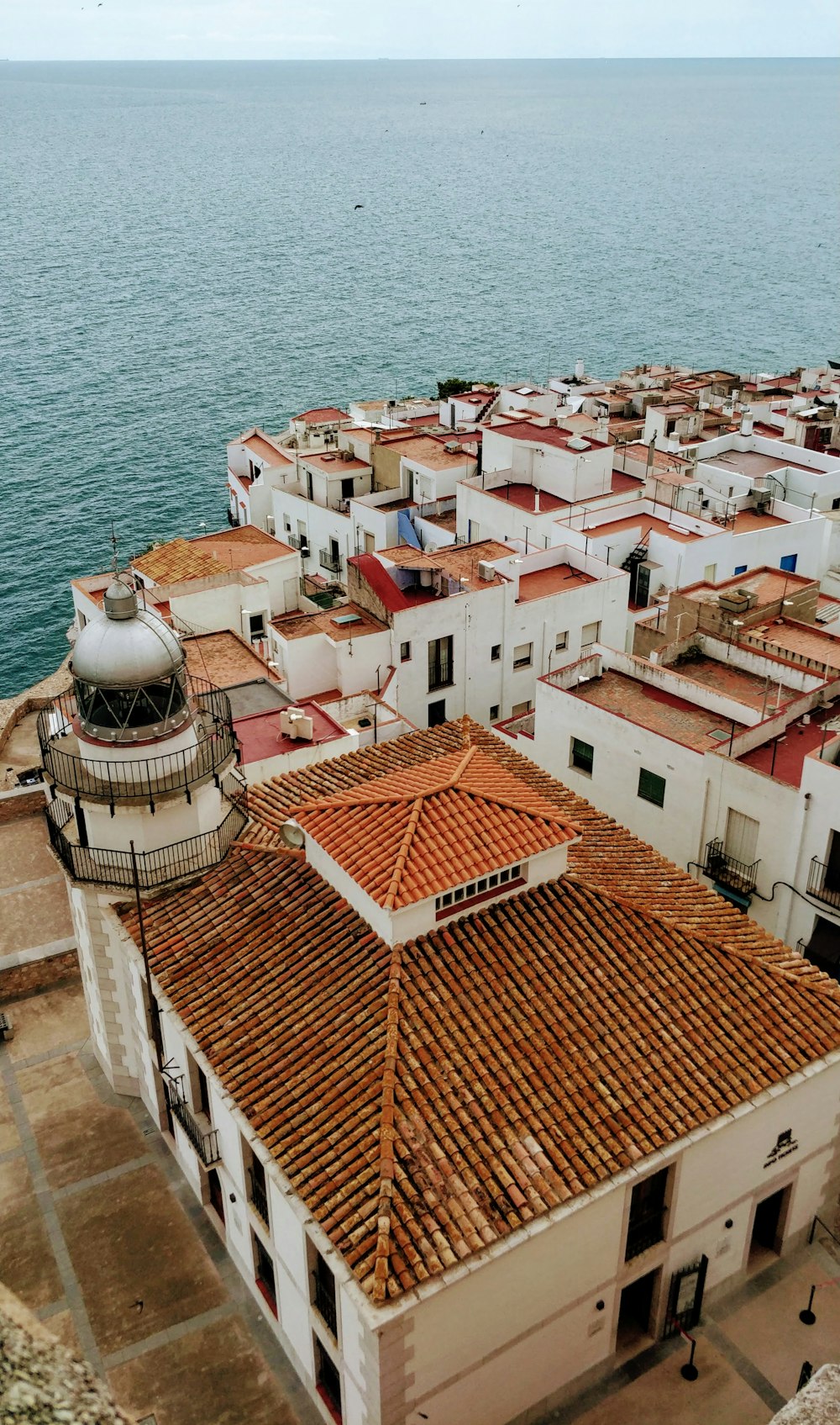 brown and white concrete houses beside sea during daytime