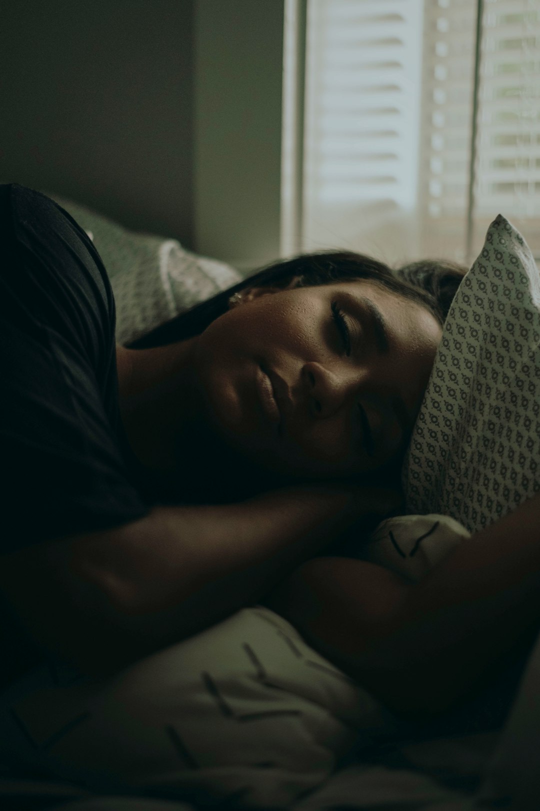 woman lying on bed with blanket