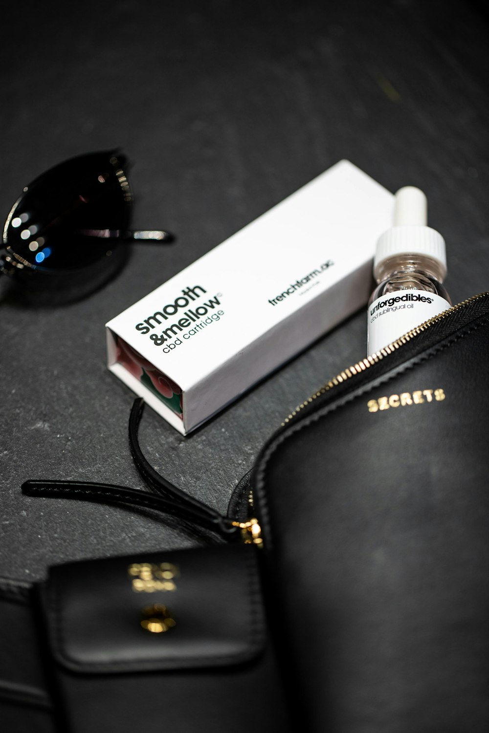 white and black labeled bottle beside black leather bag