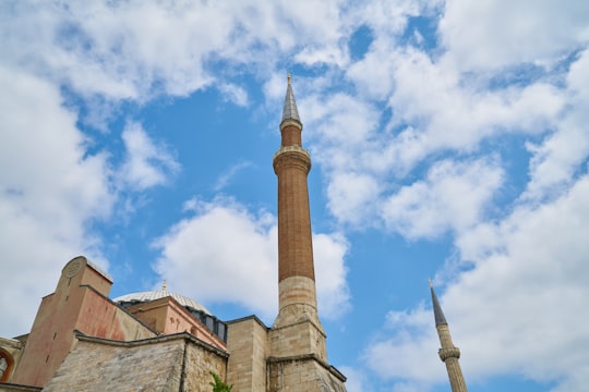 brown concrete tower under blue sky during daytime in Hagia Sophia Museum Turkey