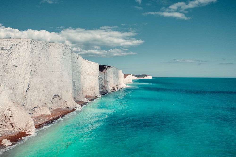 white rock formation on sea under blue sky during daytime