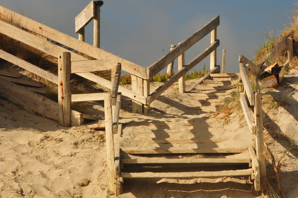 brown wooden stairs on brown sand during daytime