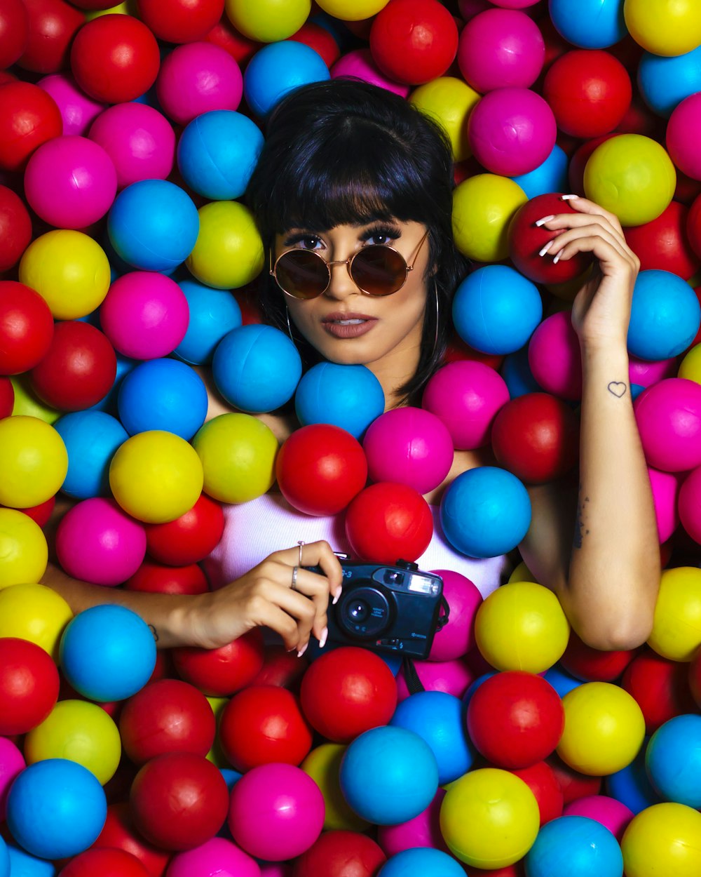 woman in black sunglasses holding balloons