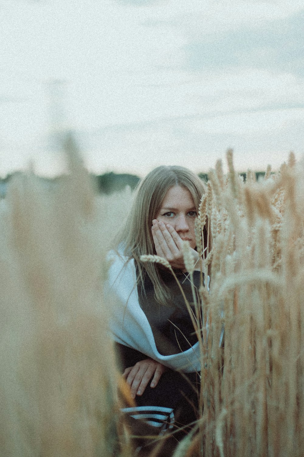 woman in blue shirt standing on wheat field during daytime