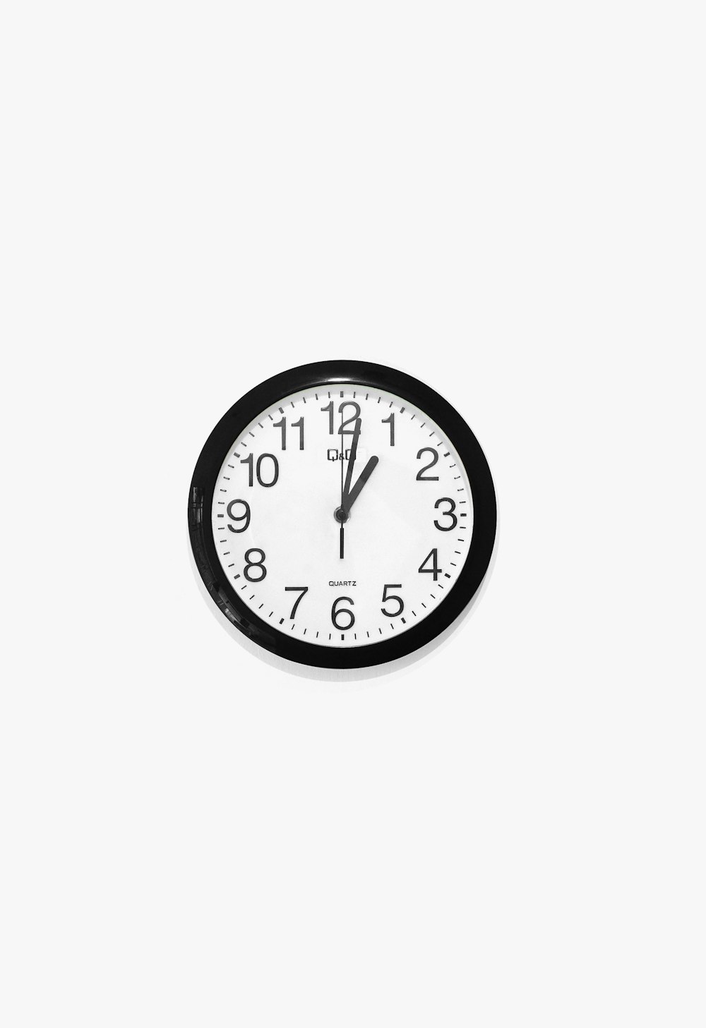 black and white round analog wall clock at 10 10