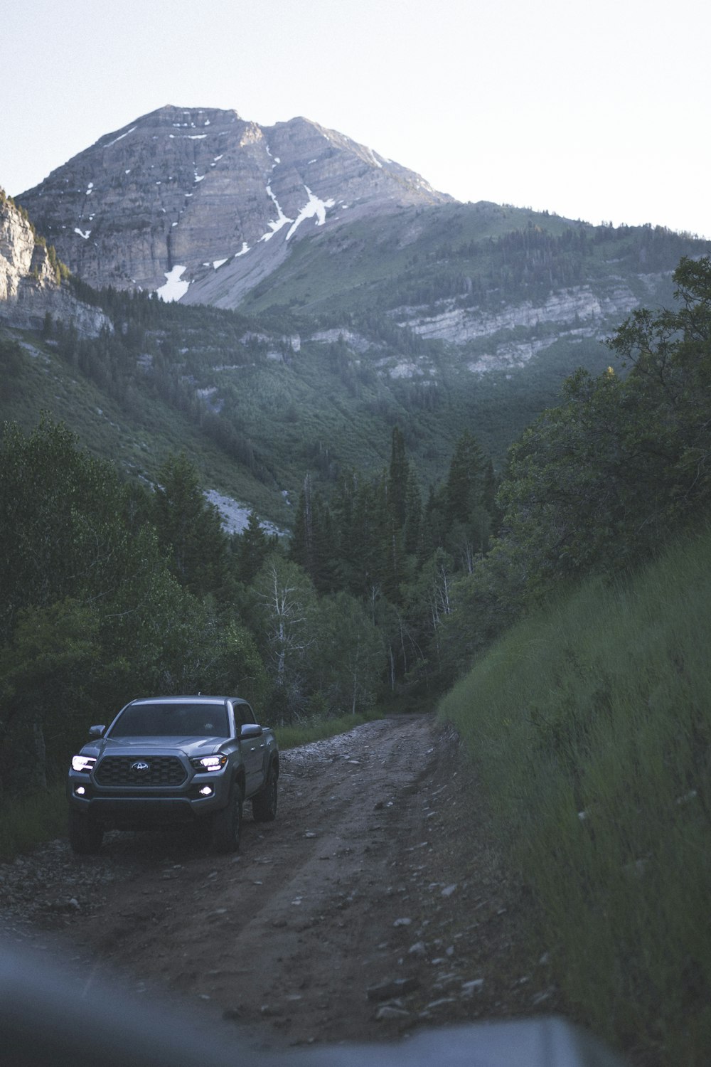 black suv on rocky road near green trees and mountains during daytime