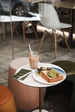 A cozy cafe table with a colorful spread of avocado toast, berry pancakes, and an iced latte under warm natural light.
