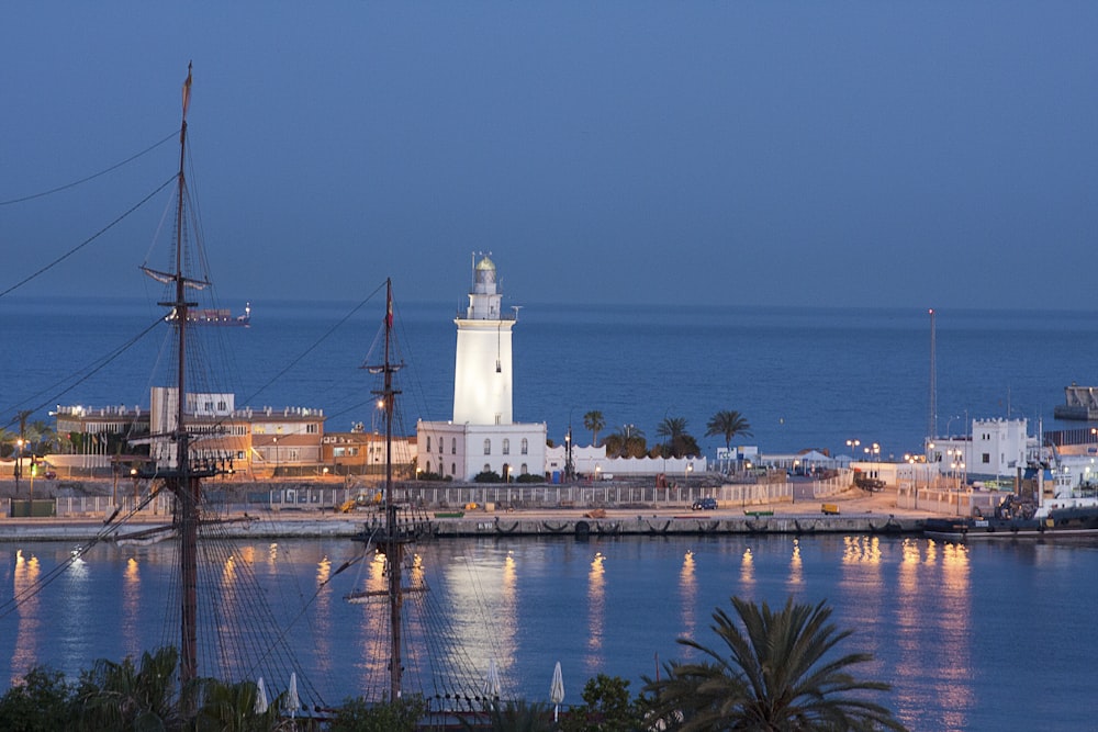 white lighthouse near body of water during night time