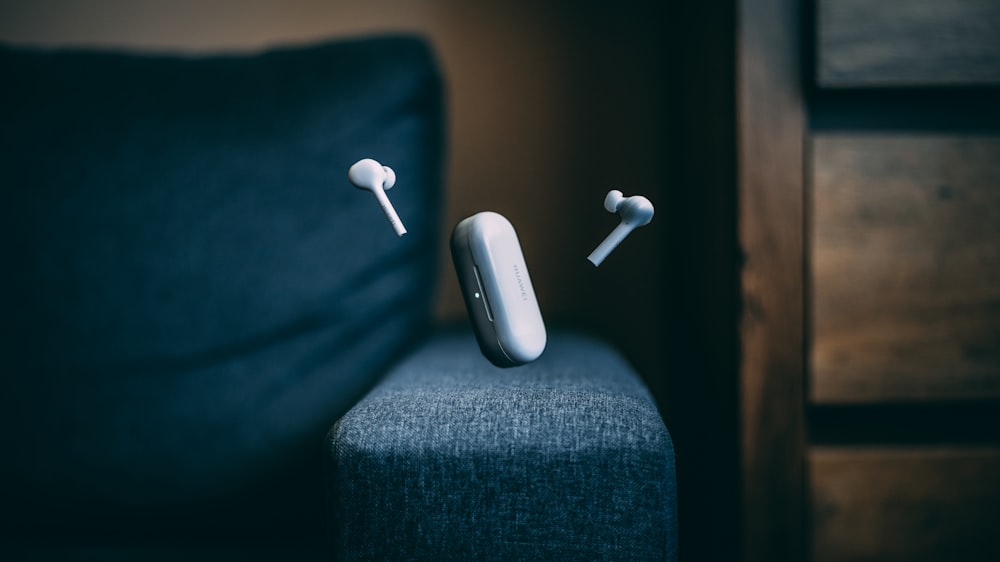 white apple earpods on black textile