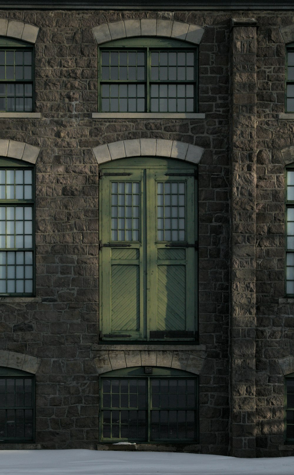 green wooden window on brown brick wall