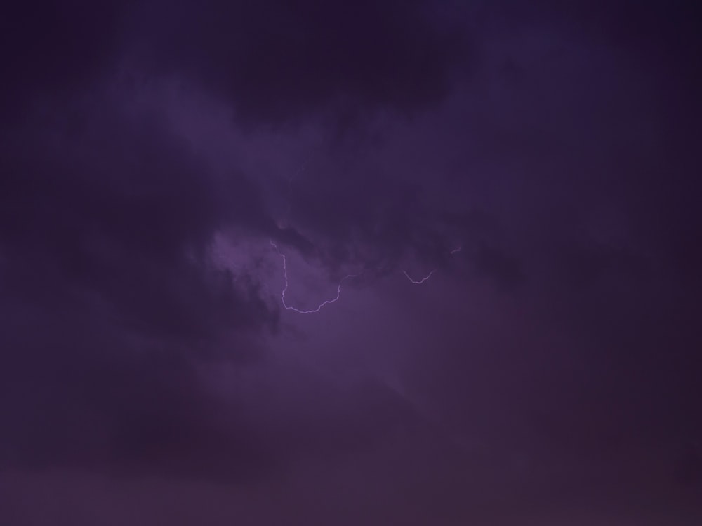 Un cielo púrpura con un rayo en la distancia