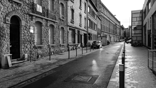 grayscale photo of people walking on street near buildings in Reims France