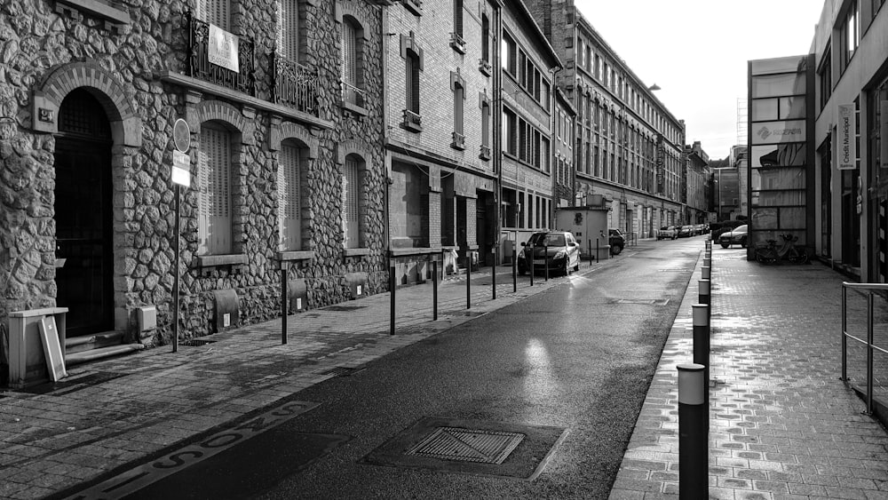 grayscale photo of people walking on street near buildings