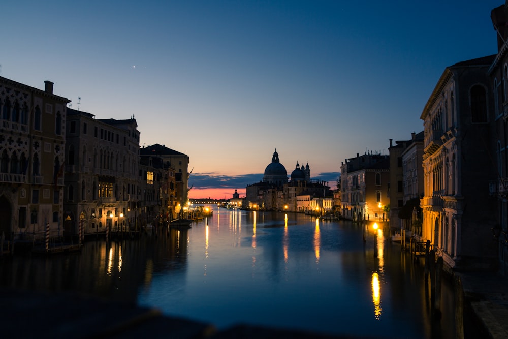 body of water near buildings during night time