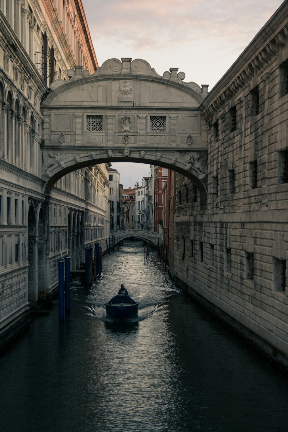 boat on river between concrete buildings during daytime