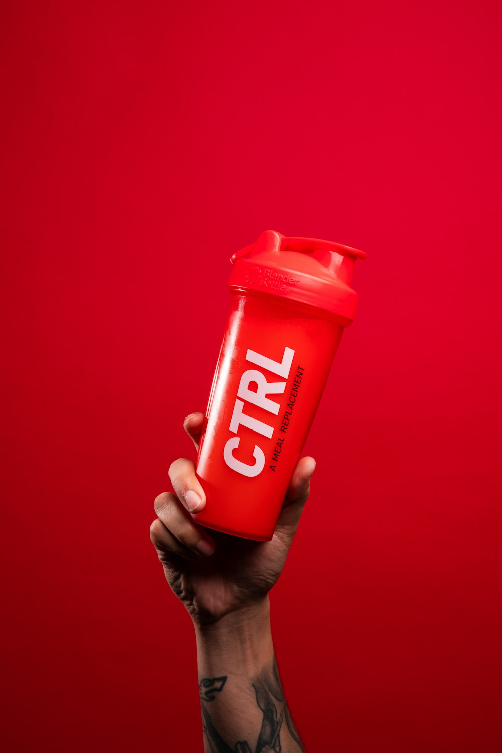 person holding red and white nescafe container