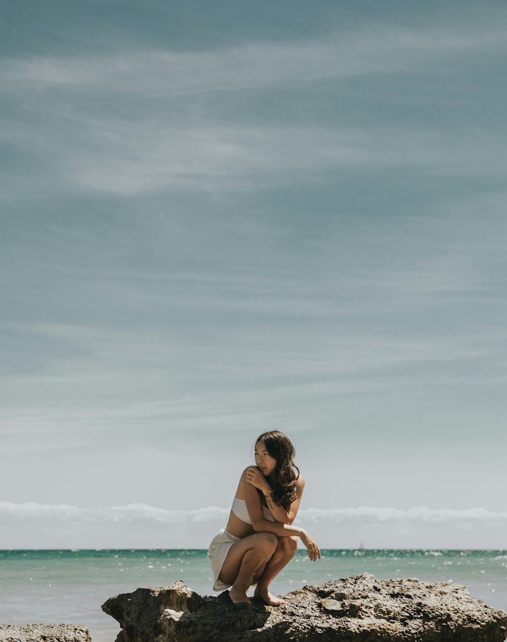 woman in black bikini sitting on beach during daytime