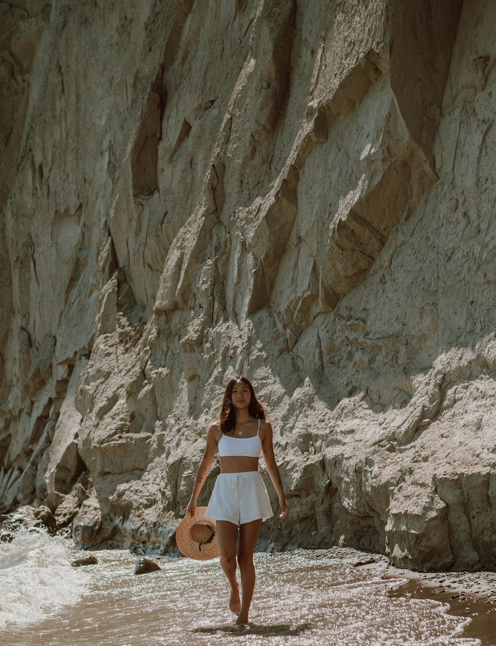 woman in white dress standing on rocky ground during daytime