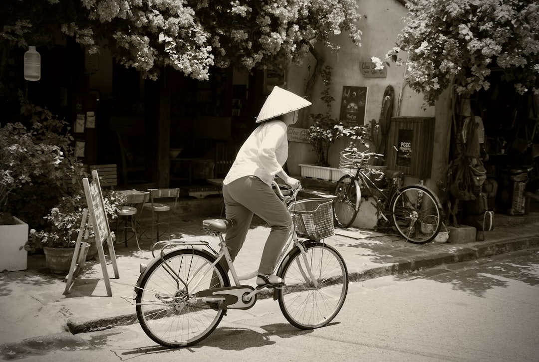 woman in white dress and white hat riding on bicycle