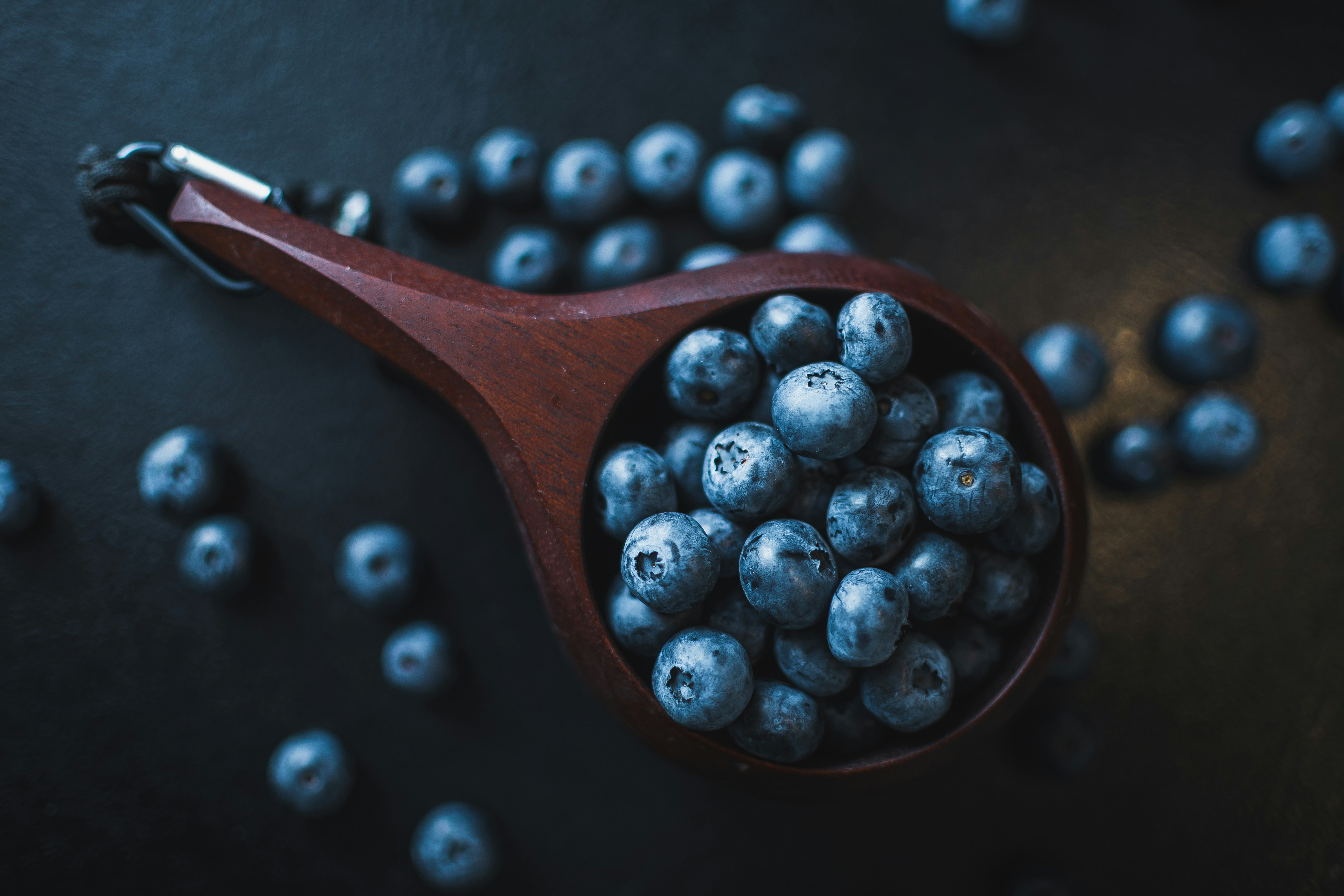black berries on brown wooden spoon