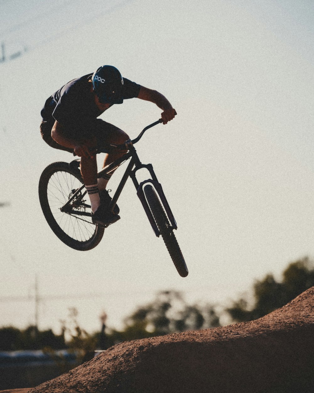 검은 색과 빨간색 셔츠를 입은 남자가 검은 BMX 자전거를 타고