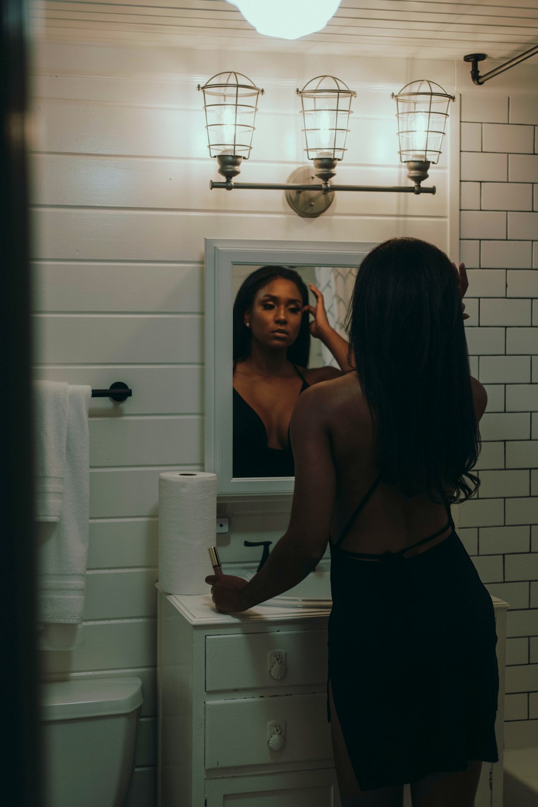 woman in black tank top standing in front of mirror