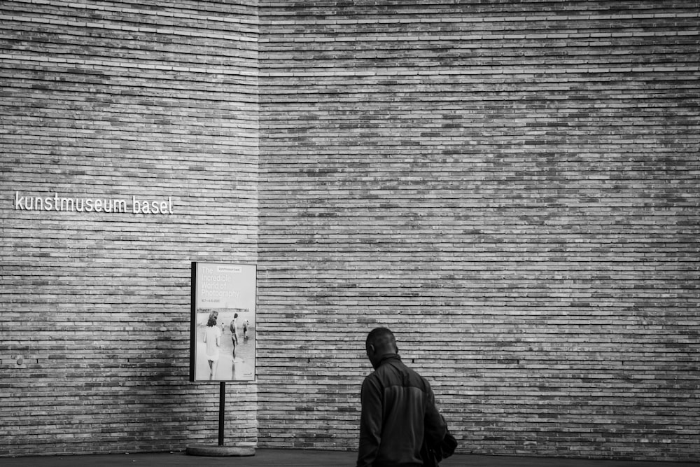 man in black coat walking on sidewalk