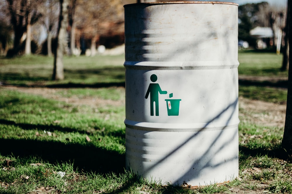 white and green trash bin on green grass field