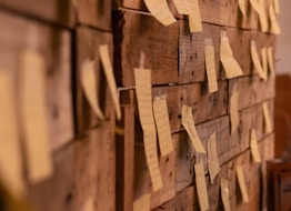 a wooden wall with post it notes attached to it