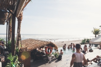 An all-inclusive resort pool scene with groups enjoying the sun and refreshing drinks.