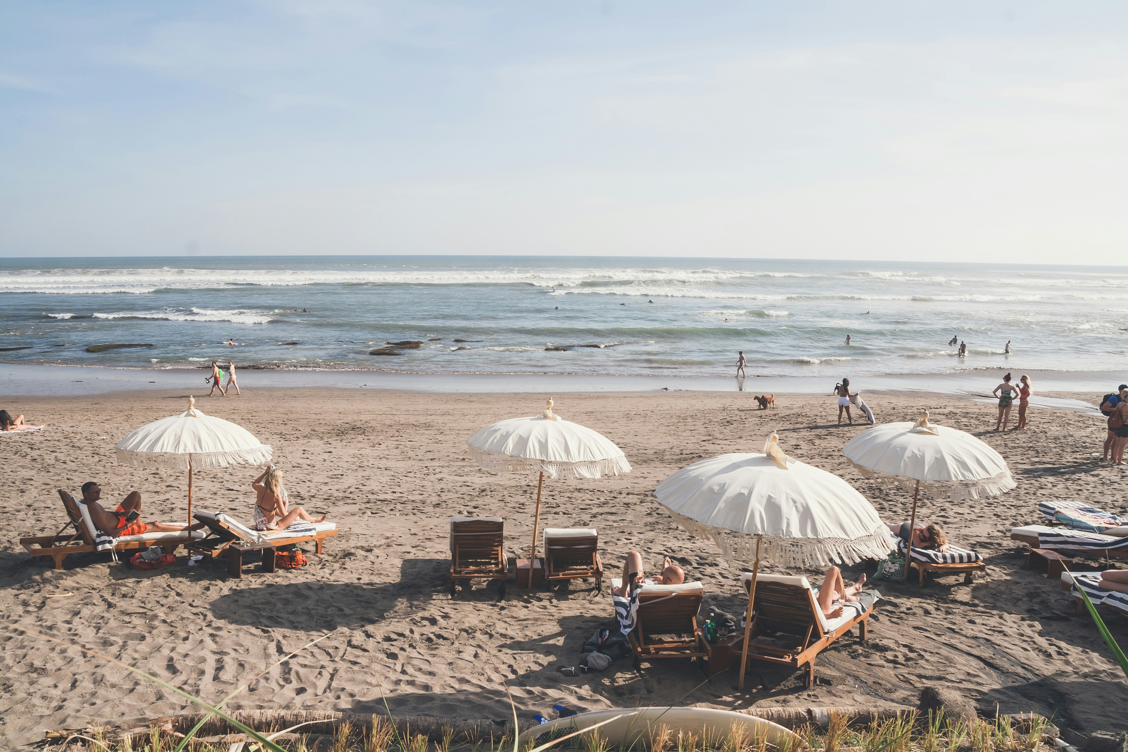 people sitting on beach chairs under white umbrella during daytime