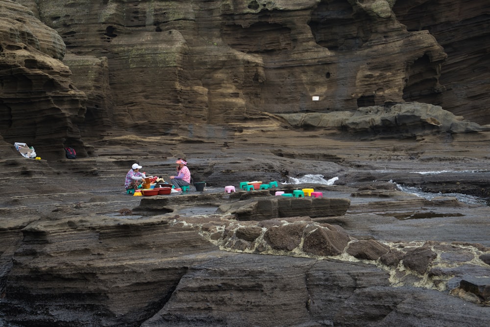 people sitting on rock formation during daytime