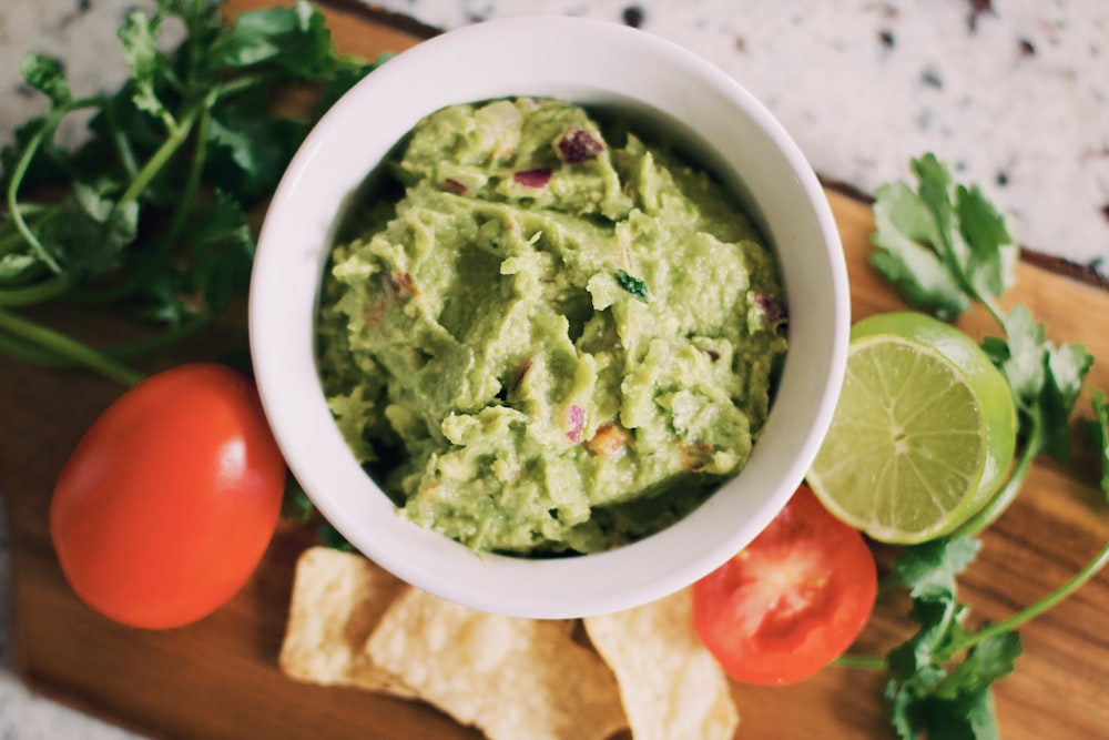 sopa verde en cuenco de cerámica blanca