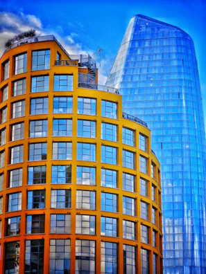 A modern building framework rising against a white and blue sky backdrop.