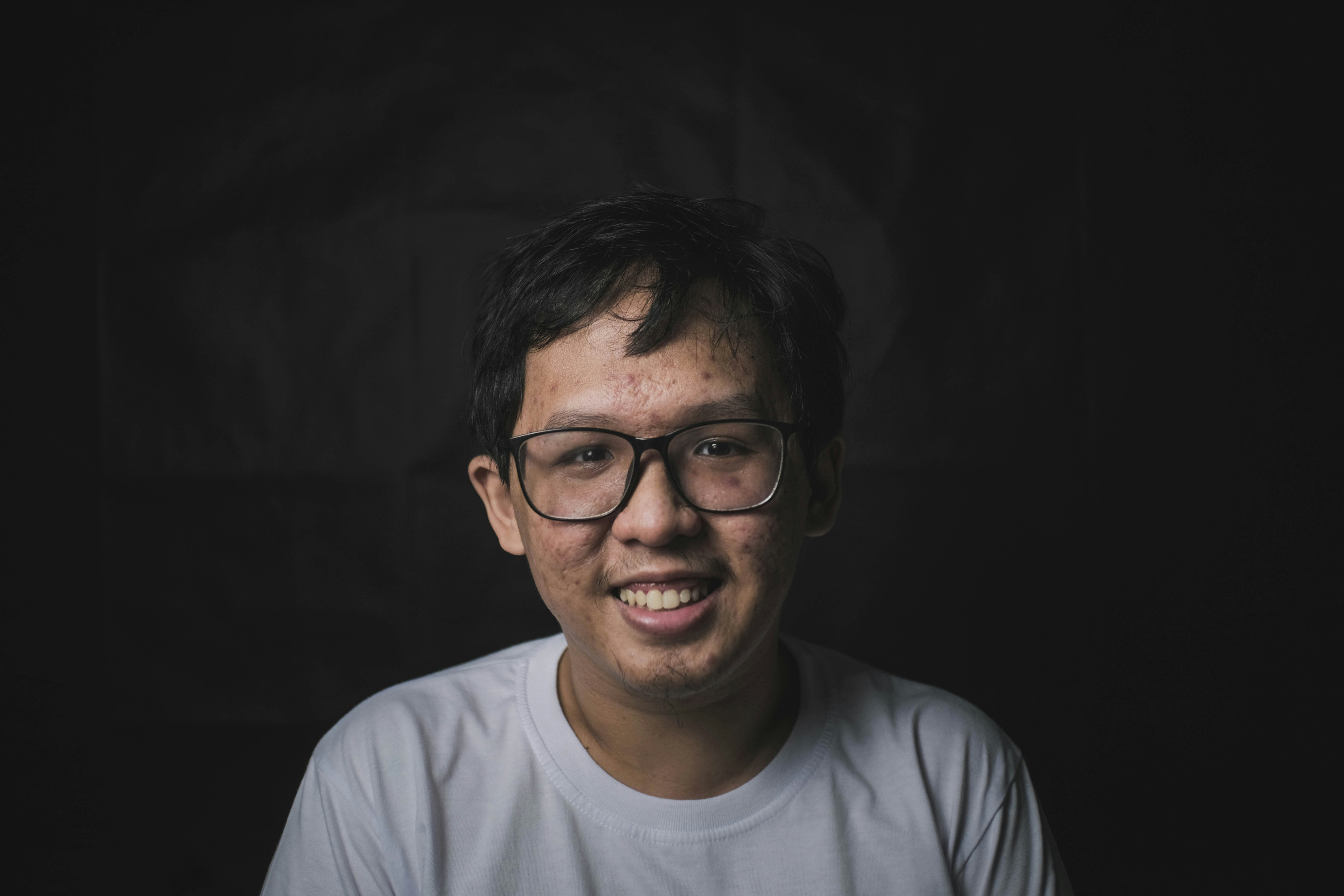 man in white crew neck shirt wearing black framed eyeglasses