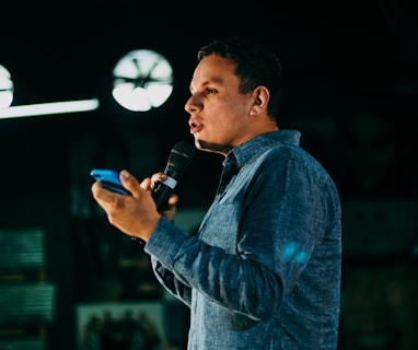 man in blue denim jacket holding microphone