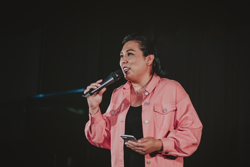 man in pink dress shirt singing