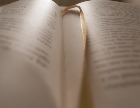 opened book on brown wooden table