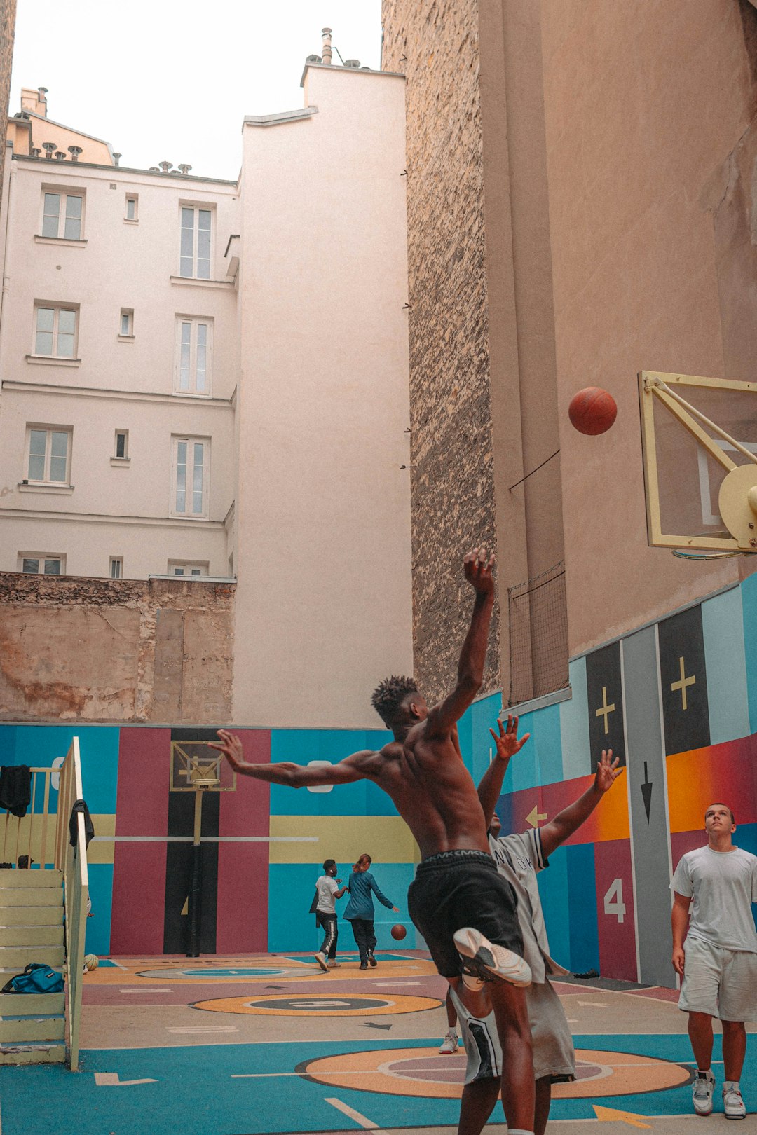 man in black tank top and black shorts playing basketball during daytime