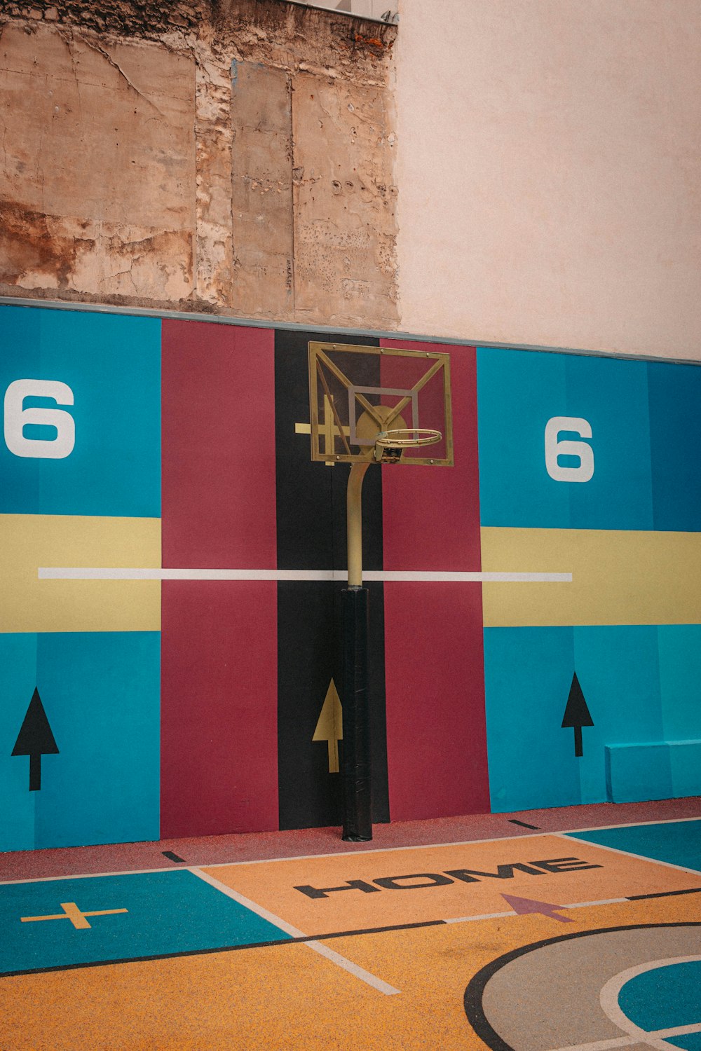 a basketball court with a mural of a basketball hoop