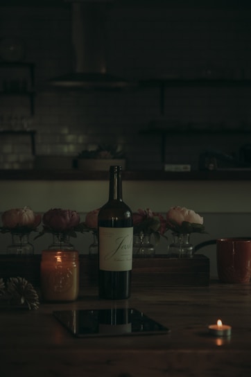 A close-up of a wine bottle with an NFC chip glowing softly, surrounded by warm candlelight.
