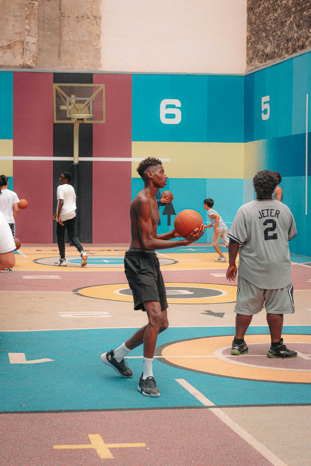 man in white shirt and black shorts standing on basketball court