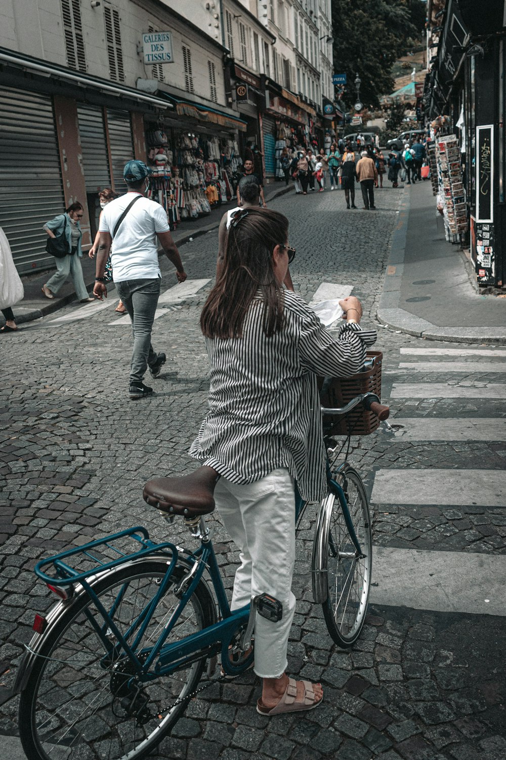 woman in black and white stripe long sleeve shirt riding on bicycle on sidewalk during daytime