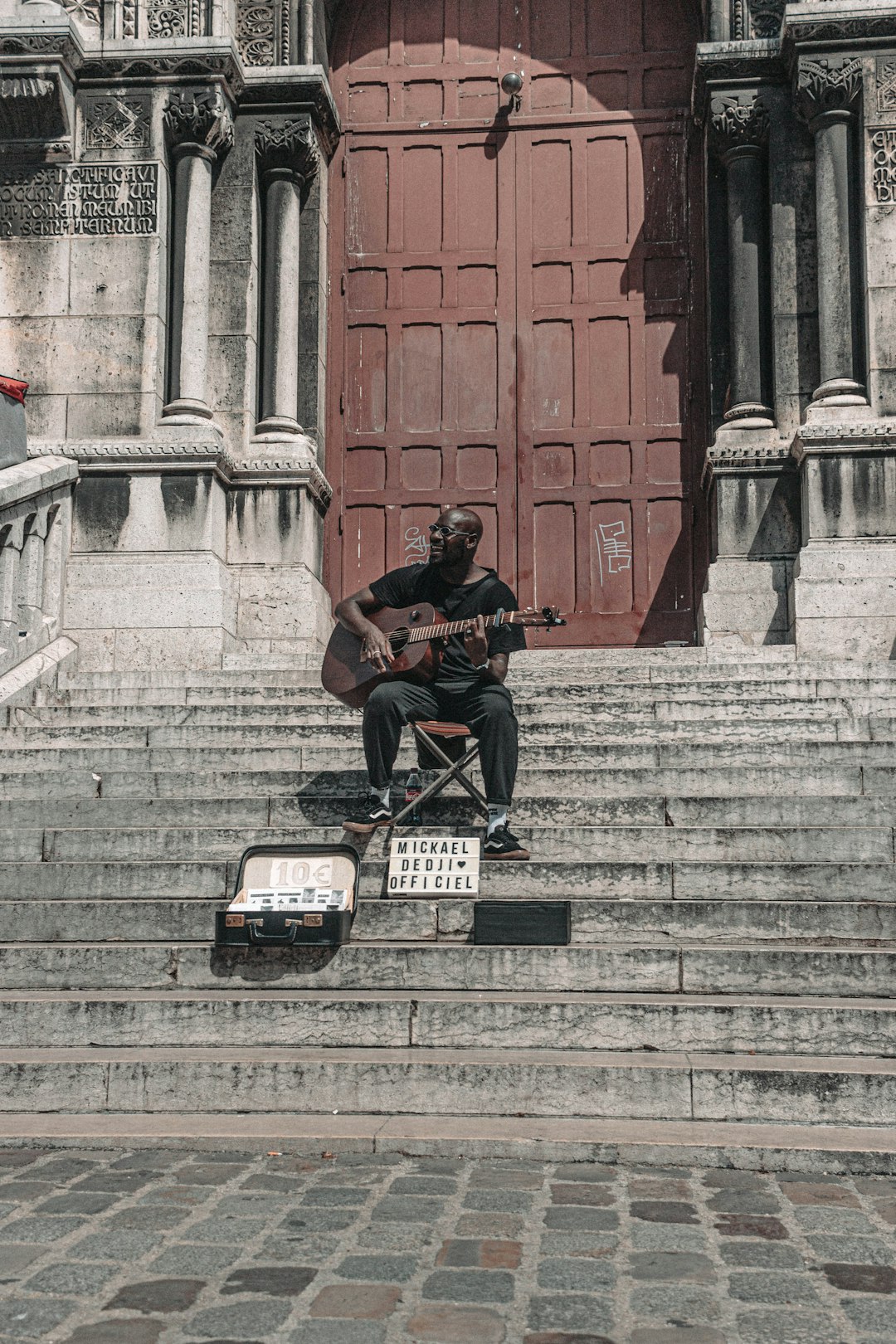 man in black jacket sitting on black steel bench